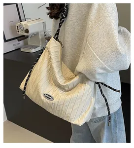 Détail du sac à bandoulière plissé blanc cassé avec bandoulière en corde tressée