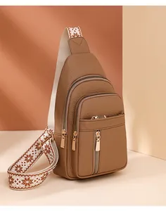 Brown lychee grain PU chest bag featuring multi-zipper pockets and geometric strap
