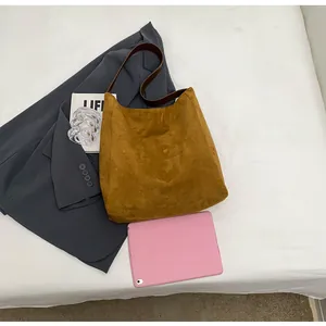 Detailed flat lay of a large vintage brown suede tote bag with a wide shoulder strap