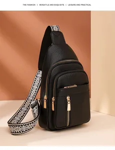 Detail of black pebbled PU leather chest bag with gold zippers and geometric strap