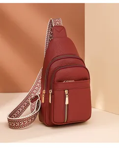 Close-up of burgundy PU leather chest bag with wave pattern strap and gold zippers