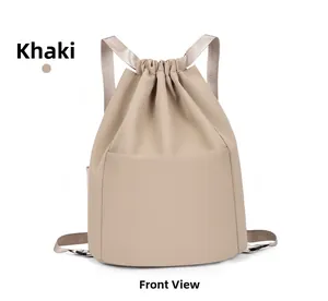 Front detail of khaki drawstring nylon backpack with woven straps and open pocket