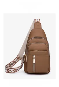 Detail of brown PU leather crossbody bag with multi-layer zippers and jacquard strap