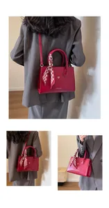 Detail der roten Brauthandtasche mit goldenem Herz und Schal am Griff