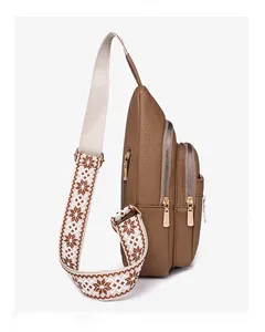 Detailed view of brown lychee texture PU leather chest bag with ethnic woven strap