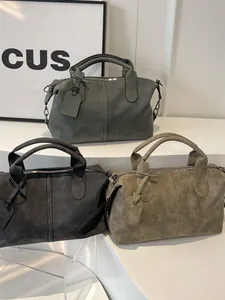 Drei matte Vintage-Boston-Taschen in Grau und Olivgrün auf Display-Stufen