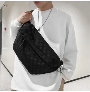 Close-up of the woven checkerboard texture and metal D-ring on this black chest bag