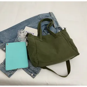 Detail of army green corduroy tote bag with side pocket and adjustable shoulder strap