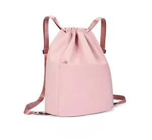 Detail of pink nylon drawstring backpack showing micro-side view and smooth fabric texture