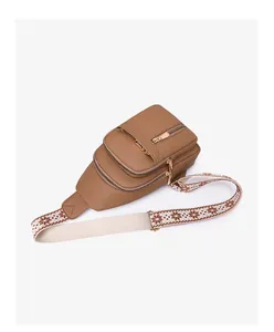 Detail of brown pebbled leather crossbody bag with ethnic patterned wide strap and gold zippers