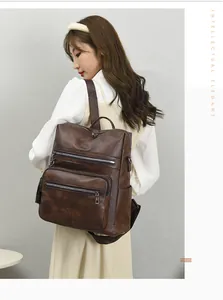 Side view of dark brown PU leather backpack on model showing layered zippers and side pocket