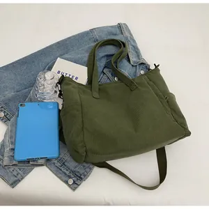 Detail of army green corduroy tote bag with side pockets and adjustable shoulder strap