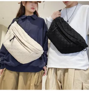 Close-up of checkerboard texture crossbody bags shown on models in cream and black colors