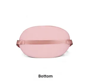 Detailed bottom view of pink nylon drawstring backpack showing reinforced strap and stitching