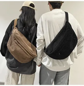 Detail of corduroy crossbody bags in black and brown showing textured fabric and large capacity