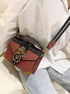 Vintage crossbody bag with golden lion head buckle and studded corners on main view