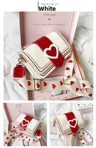Vista dettagliata della borsa a tracolla con fibbia a cuore nella sua scatola regalo rosa
