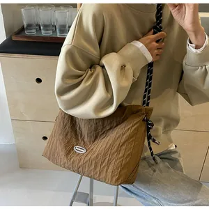 Détail du sac sous l'aisselle plissé marron avec une bandoulière en corde tressée