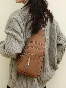 Brown faux leather crossbody chest bag with pebble texture and patterned strap