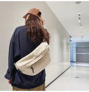 Detail of cream white chest bag with woven texture and durable black zipper hardware
