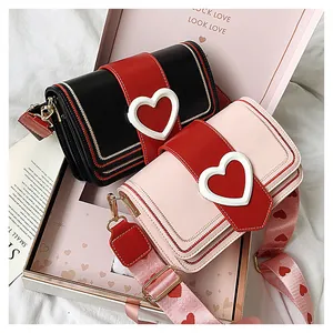 Dettagli di borse a tracolla alla moda con fibbie a cuore e ampie tracolle decorate