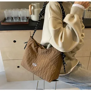 Détail du sac bandoulière plissé marron avec sangle en corde et logo de marque