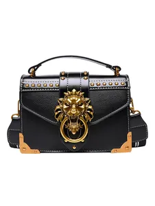 Black leather crossbody bag with gold lion head buckle and decorative metal rivets