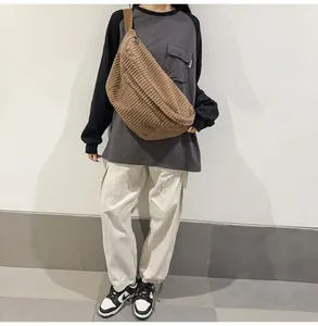 Brown corduroy crossbody bag shown on a model to demonstrate large capacity and casual style