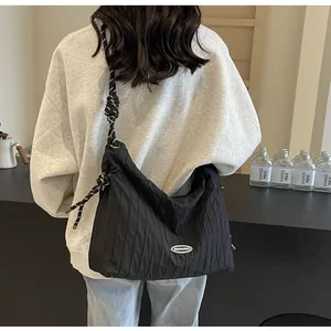 Détail du sac bandoulière plissé noir avec bandoulière en corde tressée et nœuds