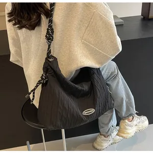 Détail d'un sac à bandoulière noir matelassé avec bandoulière en corde noir et blanc