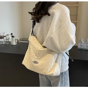 Détail du sac fourre-tout en nylon plissé beige avec bandoulière en corde noir et blanc