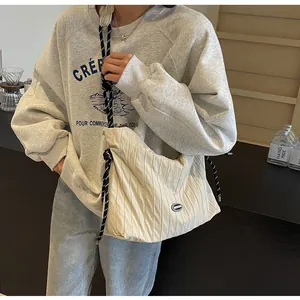 Détail du sac cabas plissé crème avec bandoulière en corde tressée noire et blanche