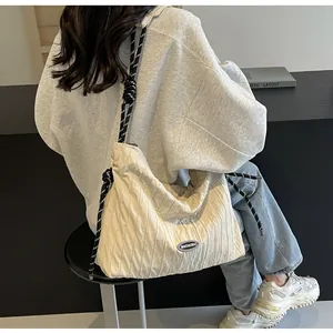 Détail du sac à bandoulière plissé blanc cassé avec sangle en corde et logo