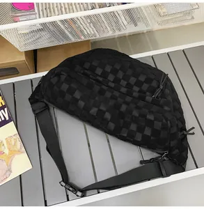 Detailed view of black checkered crossbody bag with adjustable strap and buckle closure