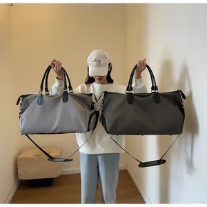 Detail of travel duffle bags in light and dark grey with adjustable shoulder straps