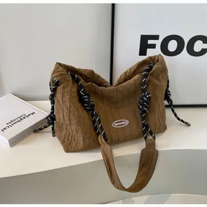 Détail du sac fourre-tout marron plissé avec poignée en corde bicolore et logo ovale