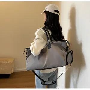 Detail showing the gray travel bag side zipper pocket and adjustable shoulder strap