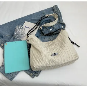 Détail d'un sac plissé avec bandoulière en corde tressée et design chic épuré