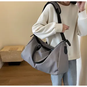 Detailed view of the large grey travel bag showing the waterproof nylon fabric and shoulder strap