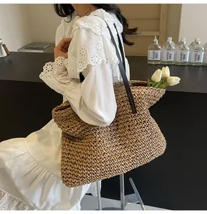 Primer plano detallado del bolso de paja tejida con correa de cuero marrón natural