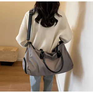 Detail view of large grey waterproof travel bag with adjustable strap and side shoe pocket