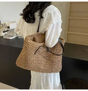 Detalle del bolso tote de paja tejida con correas de cuero y diseño de punto calado