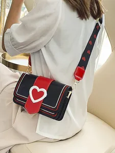Elegante borsa a tracolla nera e rossa con fibbia a cuore e ampia tracolla decorata