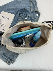 Sac à bandoulière plissé beige pour femme montrant la capacité intérieure pour iPad et parapluie