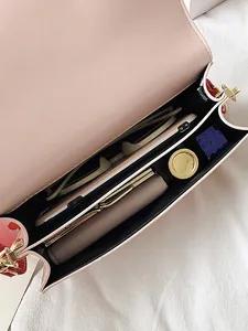Borsa a tracolla in pelle rosa con interno spazioso contenente telefono e occhiali