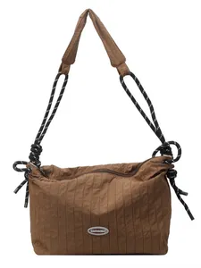 Sac sous le bras plissé marron avec bandoulière tissée et logo en métal poli