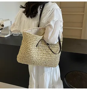 Primer plano de un bolso de paja tejido a mano con correa marrón y textura minimalista