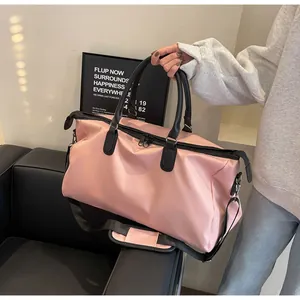 Detailed shot of a large pink travel bag with black straps and shoulder pad for fitness