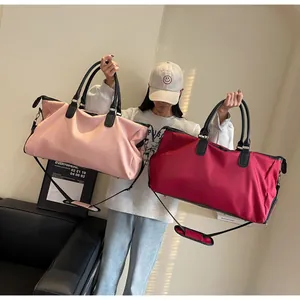 Macro view of large pink and red yoga travel bags with handles and crossbody straps