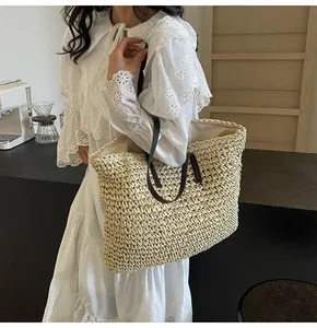 Detalle del bolso tote de paja tejida con asas de cuero en contraste y costuras finas